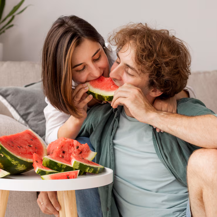 medium-shot-couple-eating-watermelon_23-2148674063